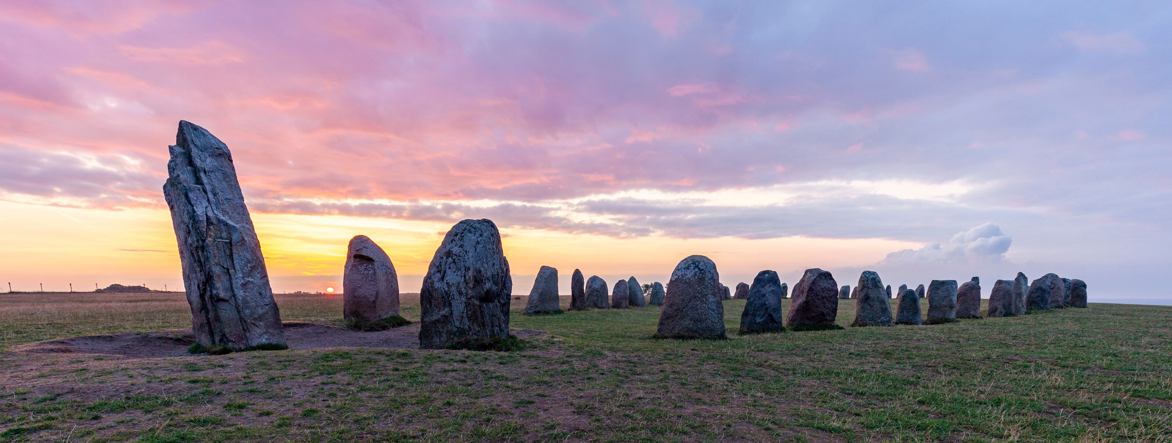 A field of standing stones at sunset.