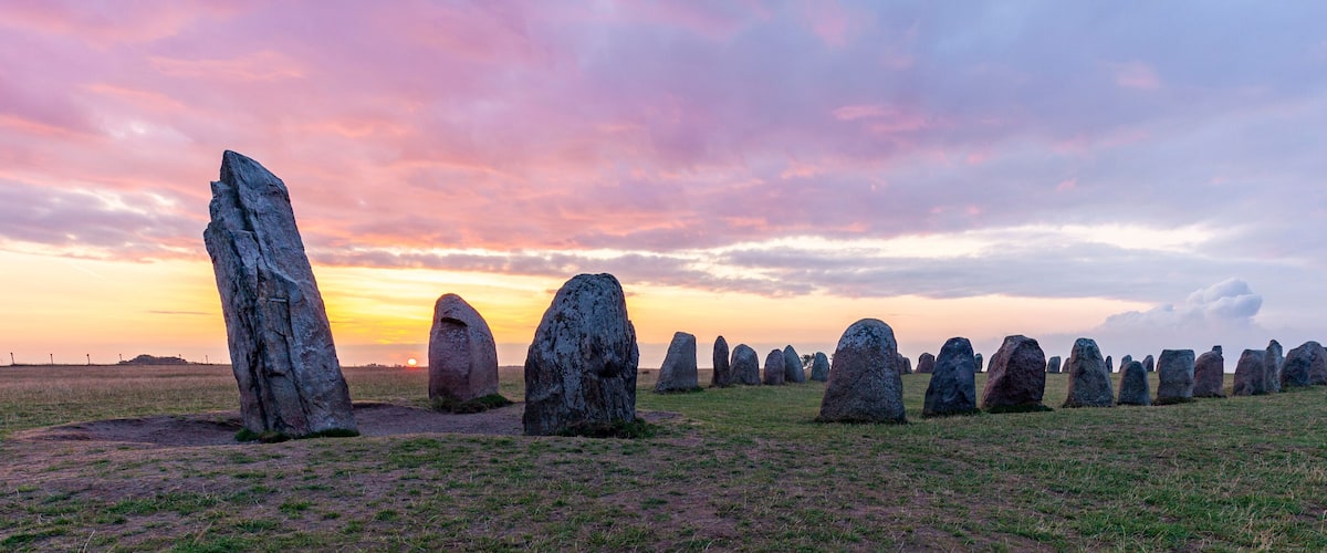 A field of standing stones at sunset.