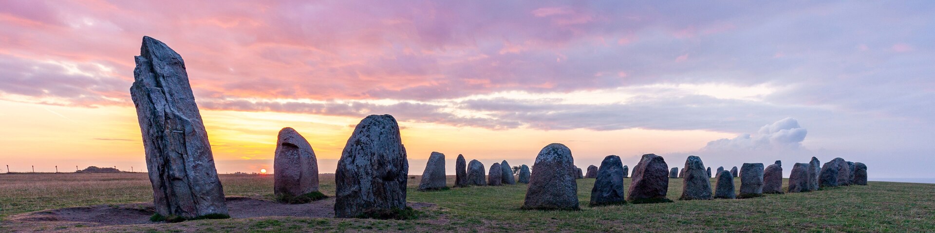 A field of standing stones at sunset.
