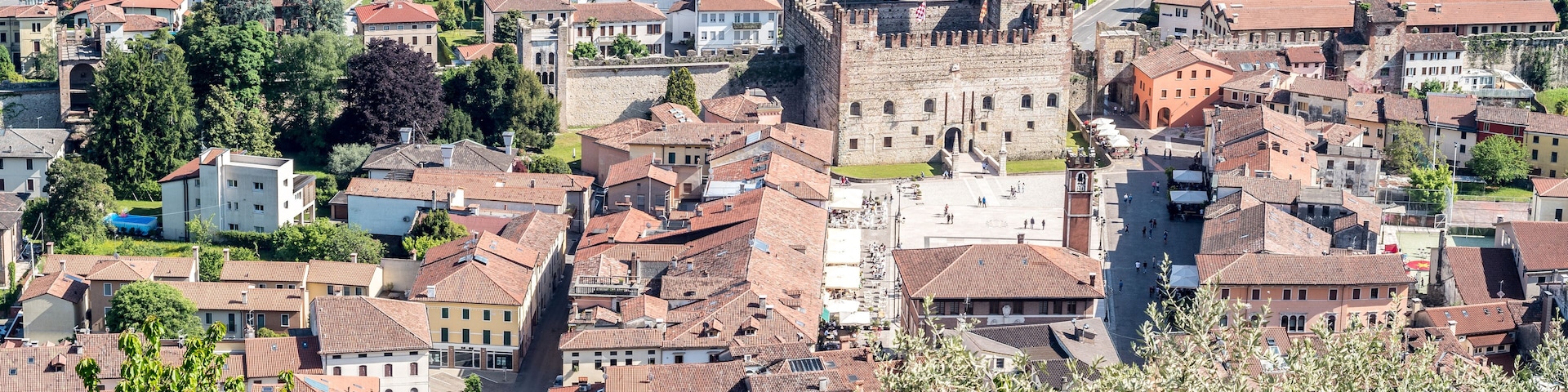 Un área urbana densamente poblada con edificios históricos y una imponente estructura similar a un castillo.