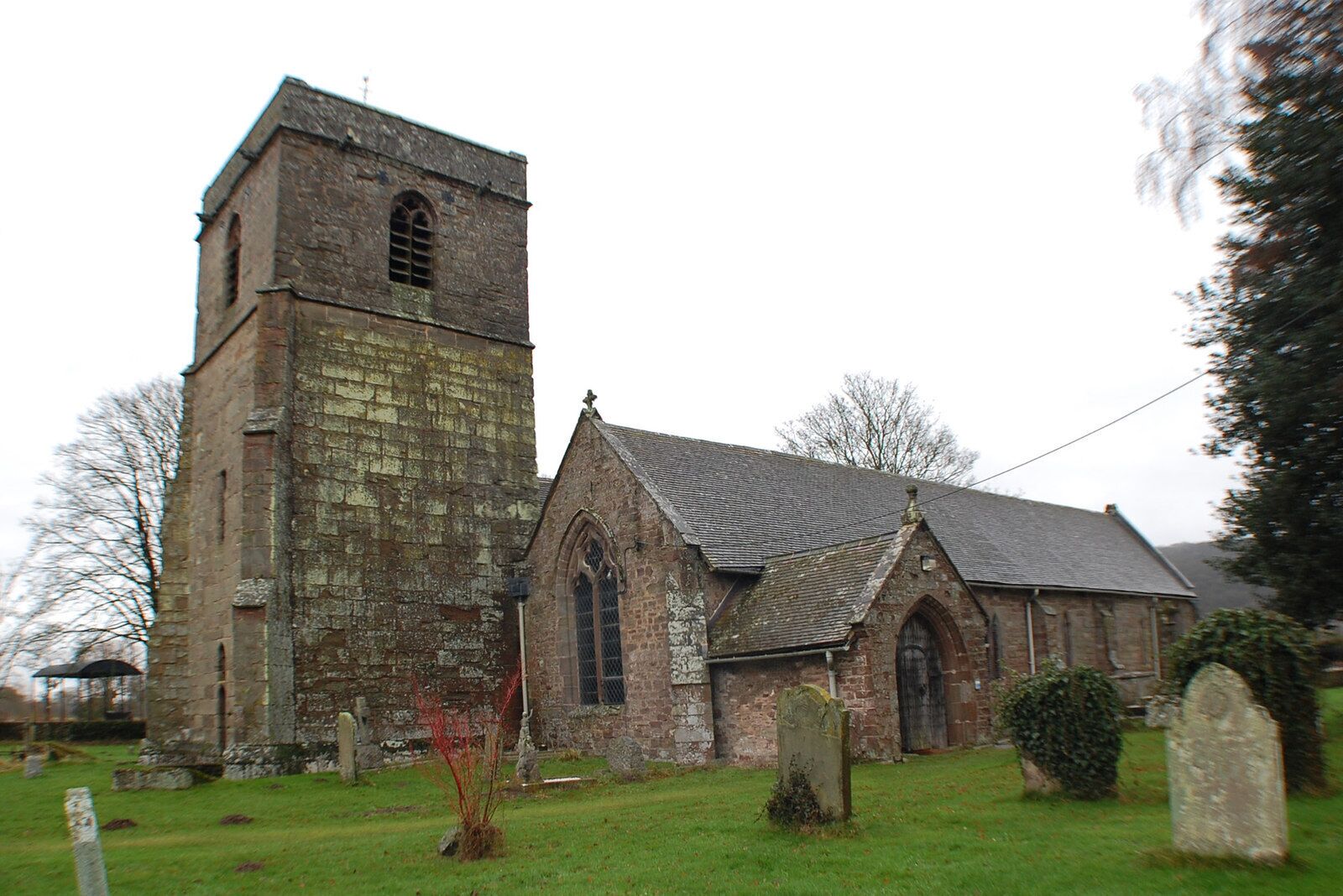 Holme Lacy is mentioned in the Domesday Book, the name means "low lying meadow belonging to the Lacys". The church is located 400m from the river Wye some 2km from Holme Lacy village. An old medieval village may have been located nearby, but no trace now remains. The church was built in the 13th C. and developed until the 17th C. It was extensively repaired in 1924. It consists of a west tower, six bay nave with square piers and two bay chancel, with south aisle (almost the same width as the nave). There is a north transept, south chapel and south porch. The oldest part of the church is the south-east corner which is 13th C. The church was altered and enlarged in 14th C. when the chancel, nave, south aisle and tower were built, although the upper stages were not completed until later. There are 8 bells. The north transept was added in late 16th to early 17th century. A font was provided by the Scudamore family in 17th C. with cherub's heads and acanthus leaves. Continuous plaster barrel ceilings were added around 1660. Repairs in 1924 centred on strengthening and straightening the nave arcade, an additional pier was inserted in the easternmost bay. The nave has a modern dormer window above the westernmost nave window. The chancel has a 13th C piscina and several 14th C windows. It is separated from the south aisle by a 13th C. 2 bay arcade. There is another piscina here; it was possibly a chantry chapel. There are several monuments to the Scudamore family here including effigies of John Scudamore and his wife Sibell on a base with Scudamore and Vaughan coats of arms. On the north wall of the chancel is a monument to James Scudamore and may be the work of Grinling Gibbons. The monument to his wife Jane is next to it. The south chapel contains a monument to James, 3rd Viscount Scudamore with cherubs and skulls. It is said to be a copy of the monument to James II of England in Paris. There are 9 vaults beneath the church. John and Sibell Scudamore, the first second and third Viscounts and other members of the Scudamore family are buried there. There is a small set of medieval misericords from 15th C. in the south aisle, and an organ by Norman & Beard of 1913 in the north west corner of the nave.