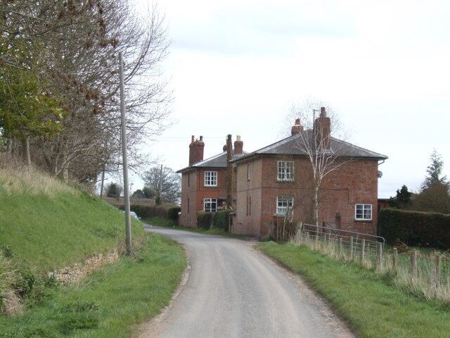 Houses by the Roman Road These matching red-brick houses probably originally housed workers at Home Farm, out of shot to the left. The Roman road here bends around the foot of Garnons Hill.