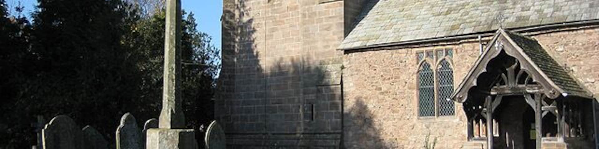 Stone cross in St Peter's parish churchyard, Withington, Shropshire. A 19th-century shaft and head on a 14th- or 15th-century base and steps.