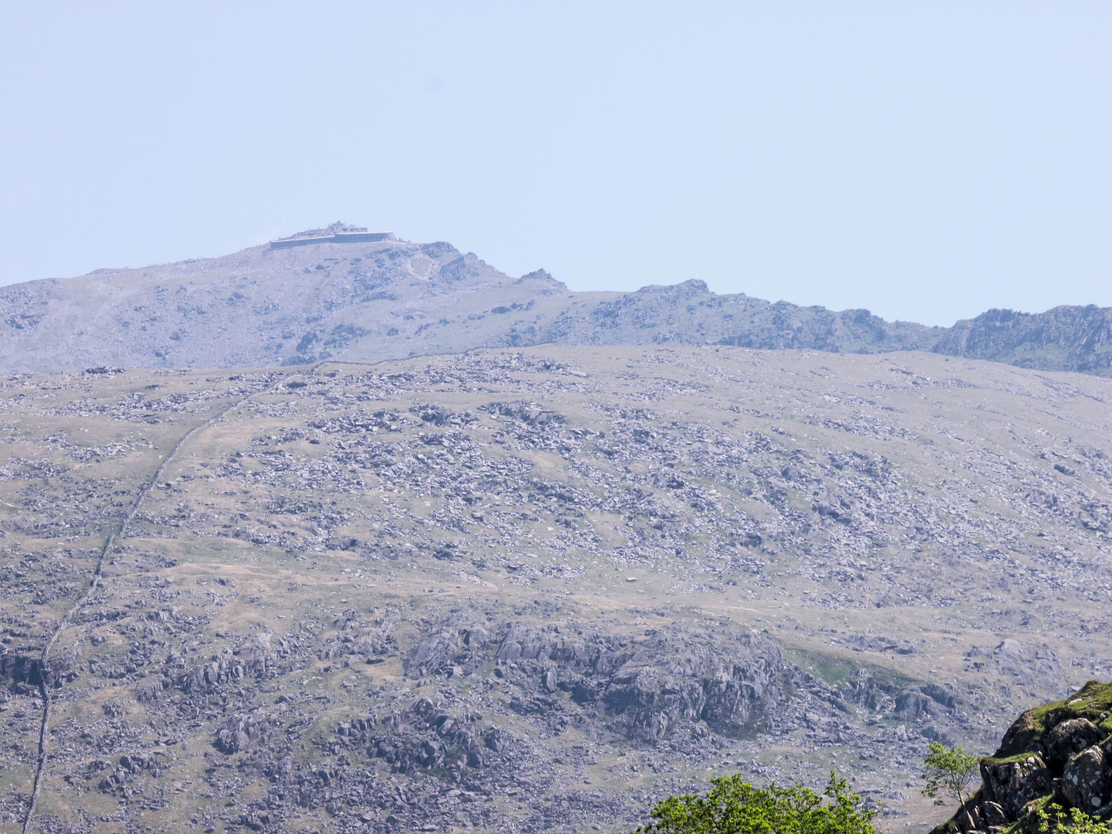 A rugged mountain landscape with rocky terrain and sparse vegetation.