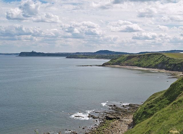 View from cliffs south of Long Nab Showing the headlands of Cromer Point, Scalby Ness and Scarborough Castle Hill. The hill on the horizon in the centre is Oliver's Mount.