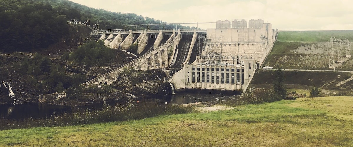 A large dam with multiple spillways and a power station.