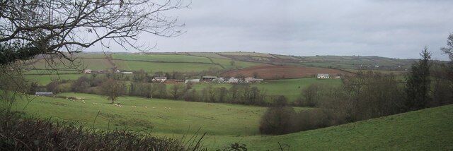 Rolling green hills, a small village, and a distant hill.
