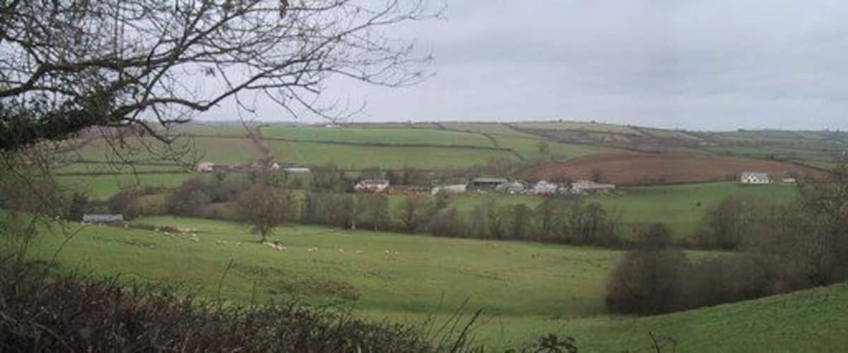 Rolling green hills, a small village, and a distant hill.