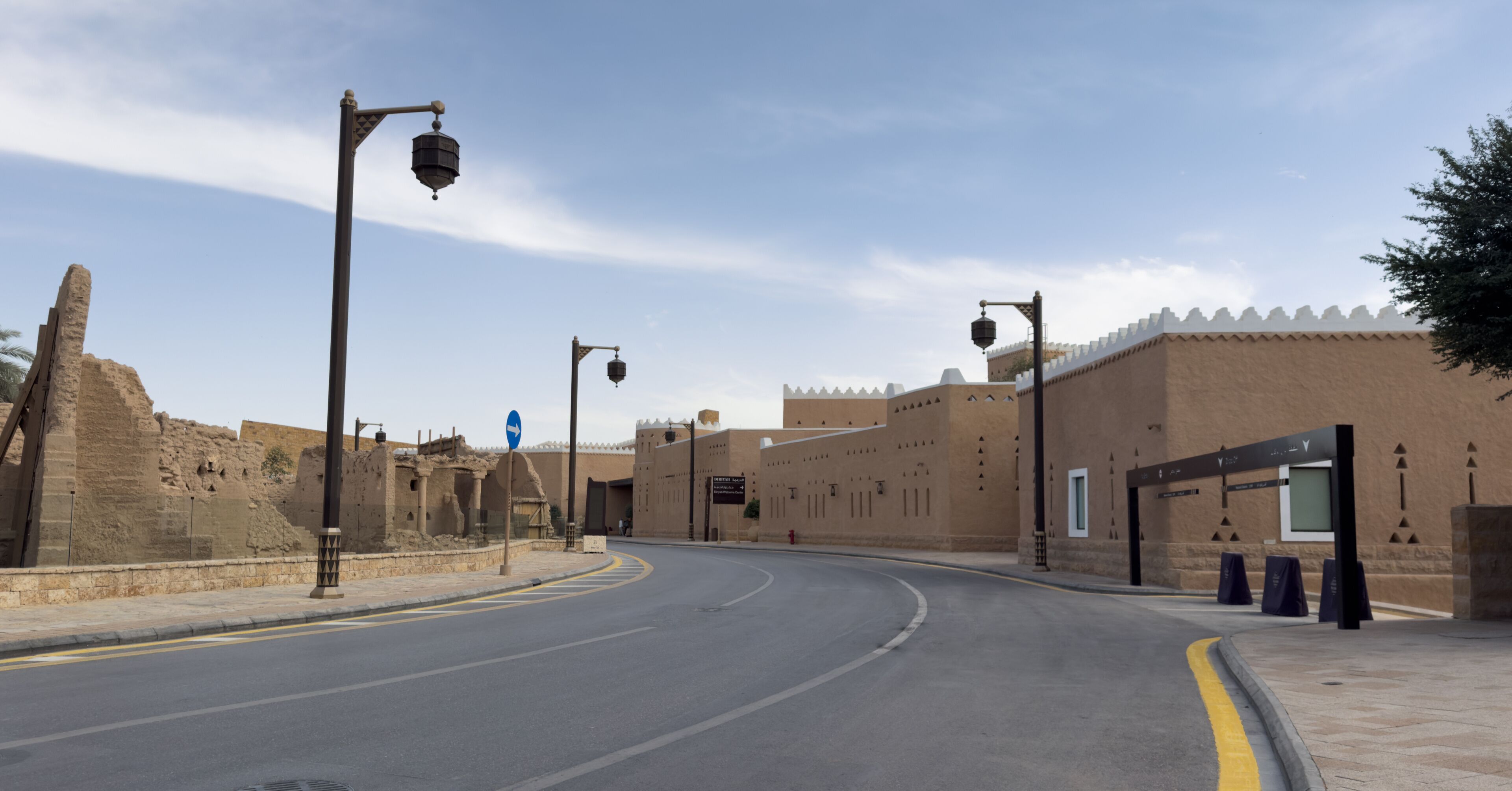 A road curving through a historic site with ancient ruins and modern buildings.