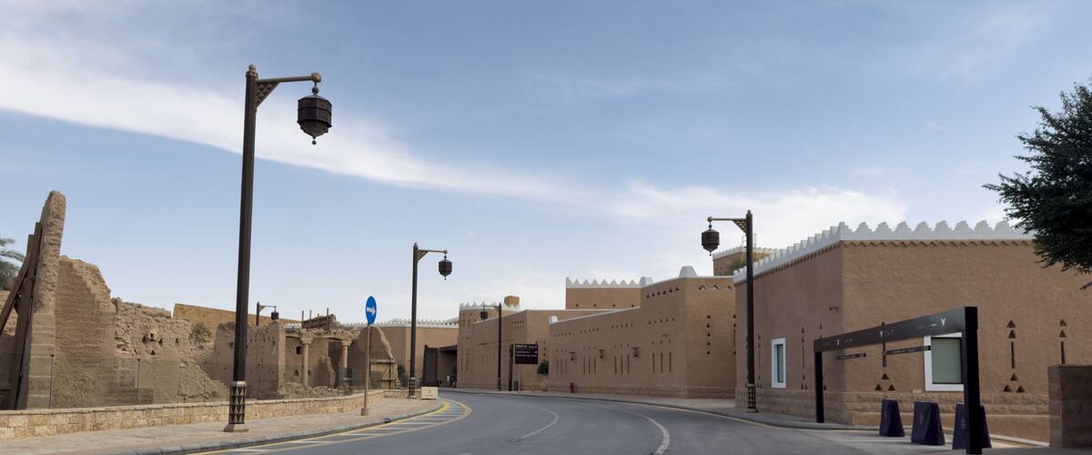A road curving through a historic site with ancient ruins and modern buildings.