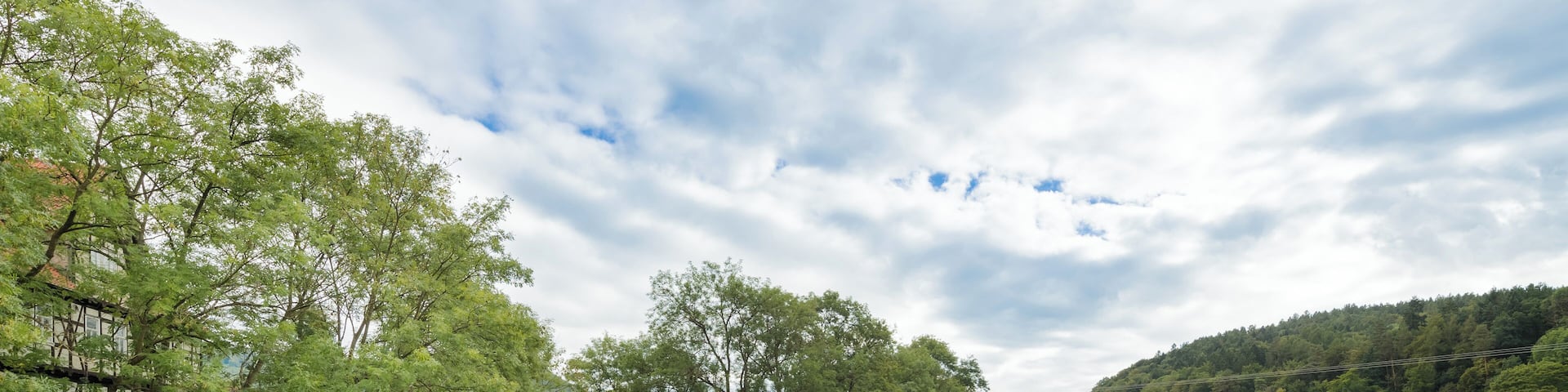 Die Werra bei Wanfried von der Wanfrieder Werrabrücke aus gesehen. Der linke Flussarm (Mühlgraben) dient zur Versorgung des Elektrizitätswerks Wanfried, dessen Gebäude im Hintergrund sichtbar ist. Vor der Insel in der Flussmitte ist ein Floß angelegt. Im linken Bildteil ist ein Teil der großen Schlagdhäuser zu sehen. Blickrichtung Süden.
