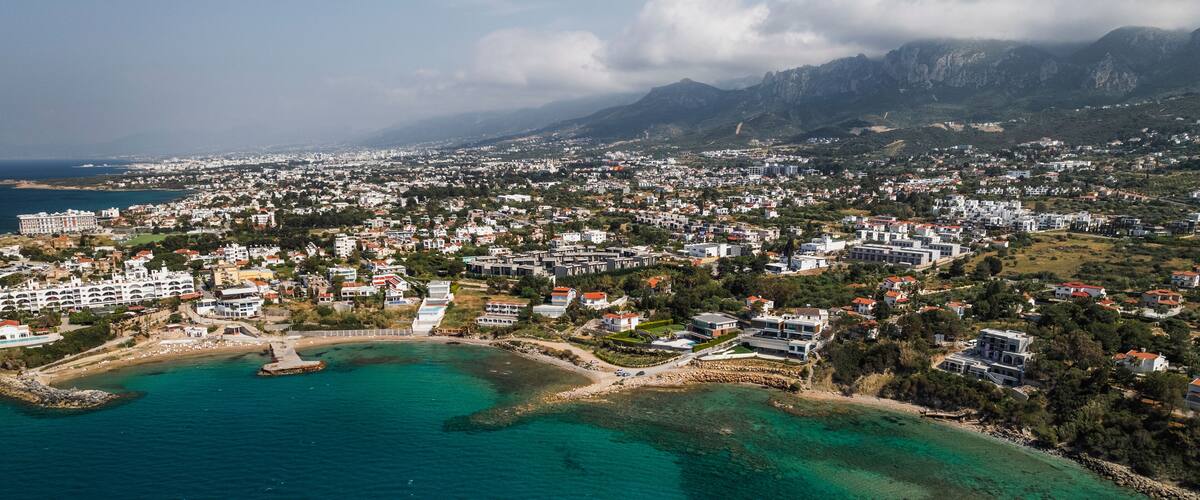 Aerial view of picturesque coastal town with beautiful beach and tranquil sea, Karavas, Kyrenia, Turkish Republic of Northern Cyprus.