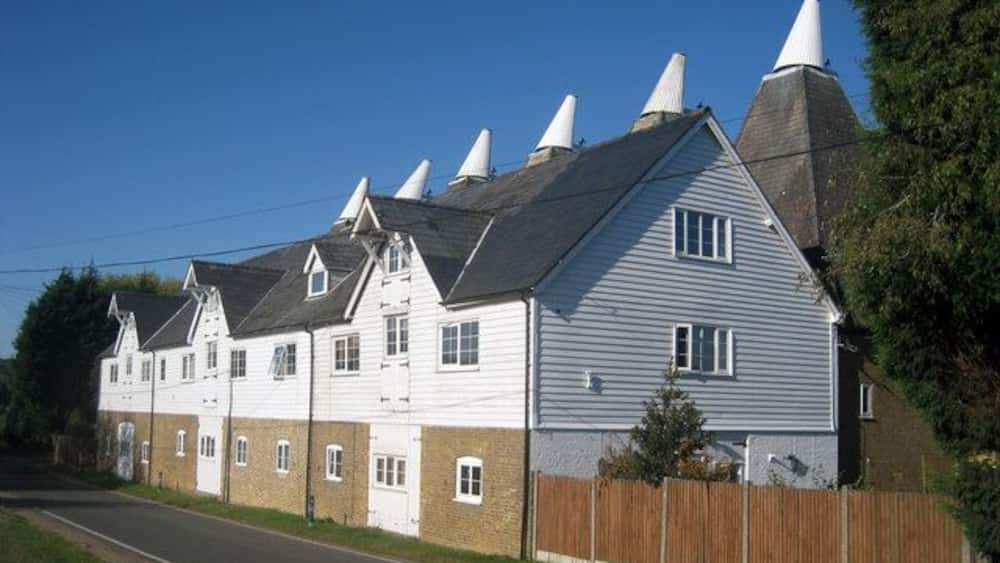 A row of white houses with grey roofs and white chimneys.
