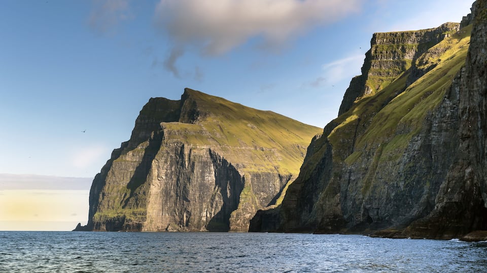 A rugged coastline with steep cliffs and a calm sea.
