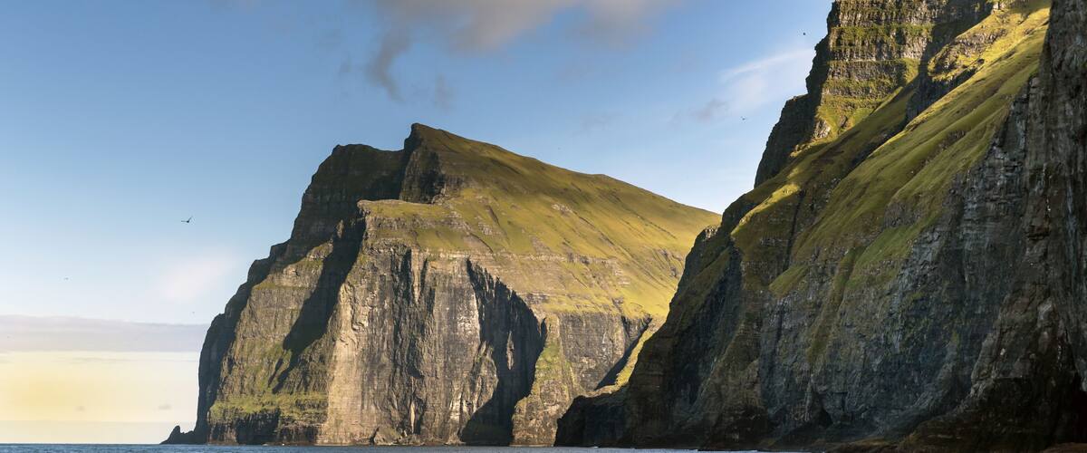 A rugged coastline with steep cliffs and a calm sea.