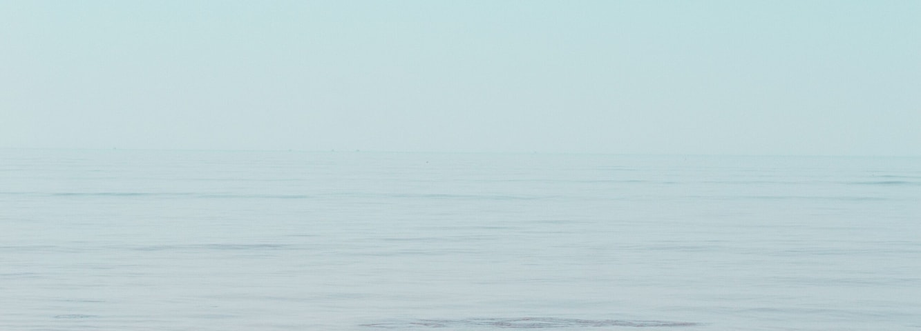 Uma praia com ondas calmas e céu claro.