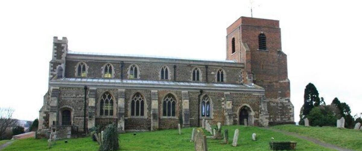 A historic church with a bell tower and a graveyard.