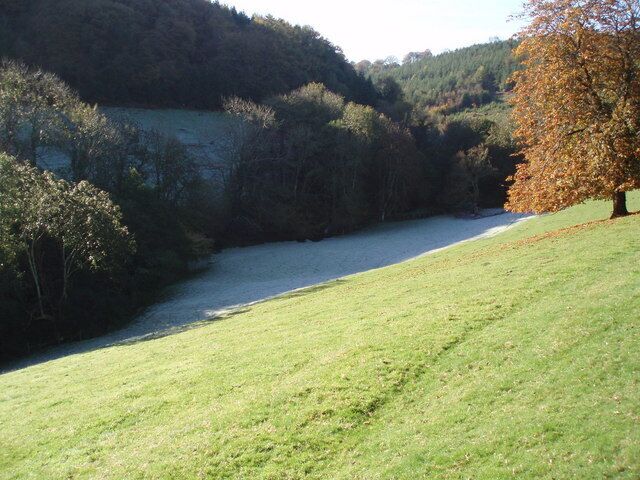 Ground frost and autumn sunshine Chargot Wood in the background.