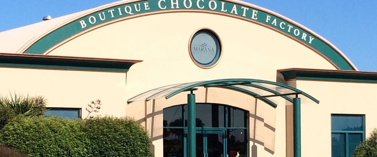 A building with a sign that reads "Boutique Chocolate Factory" and a Makana logo.