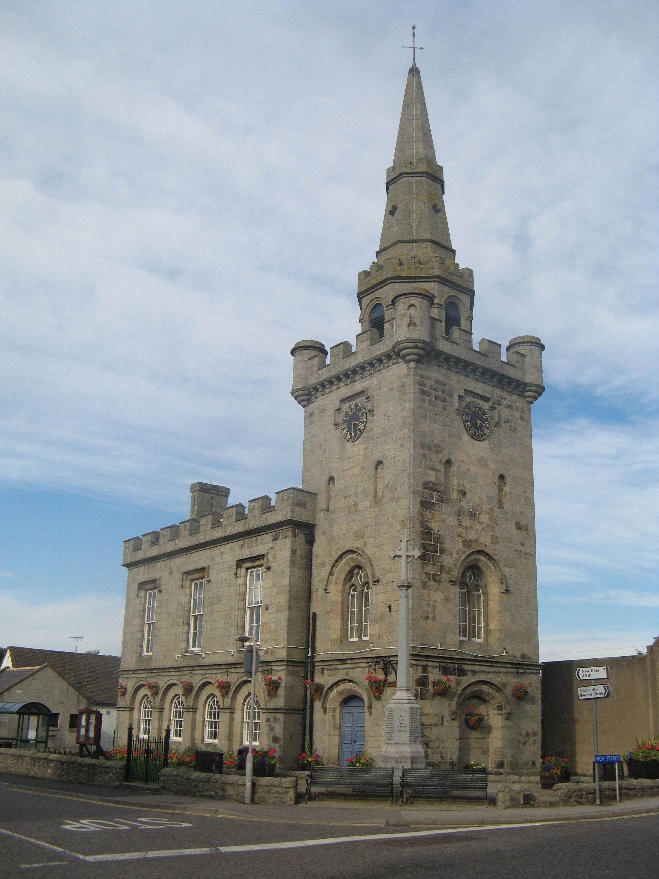 A historic stone church with a tall spire and arched windows.