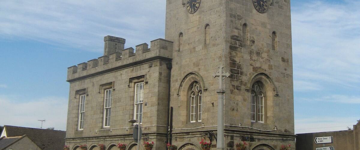 A historic stone church with a tall spire and arched windows.