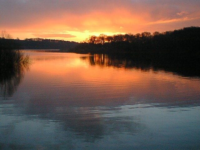 Sunrise across Chapel Bay on Ogston Reservoir at Brackenfield, Derbyshire, England
