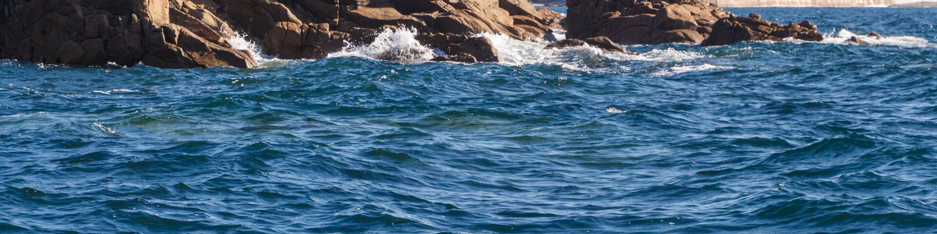 Coast in Brittany with Primelin village and breakwater in the background