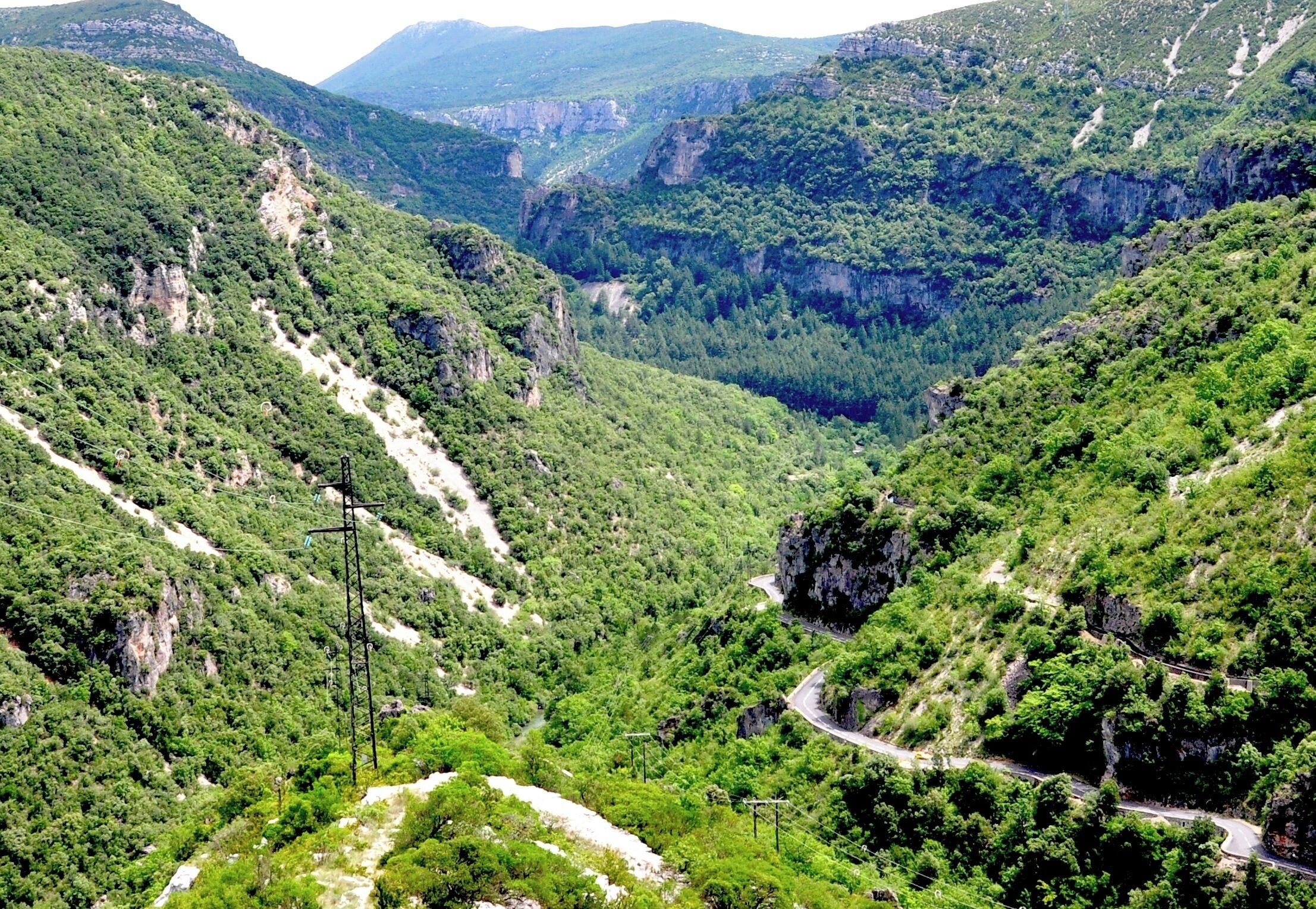 A mountainous landscape with winding roads and dense greenery.