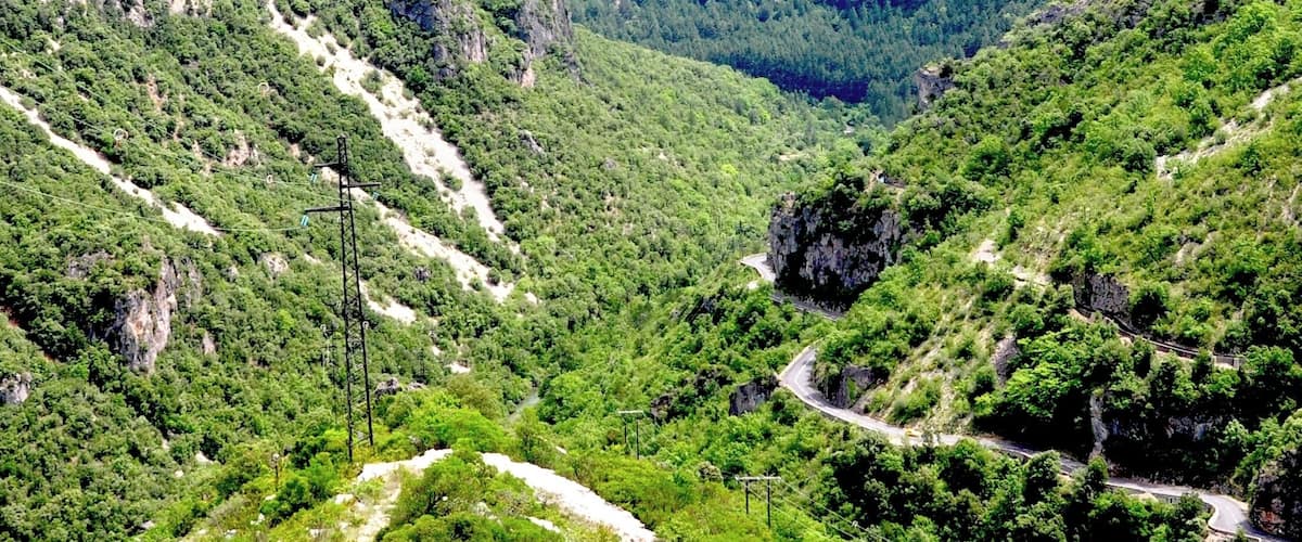 A mountainous landscape with winding roads and dense greenery.
