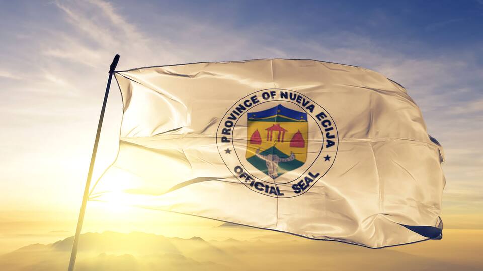 A flag with the text "PROVINCE OF NUEVA ECUADOR OFFICIAL SEAL" fluttering against a backdrop of a sunrise or sunset.