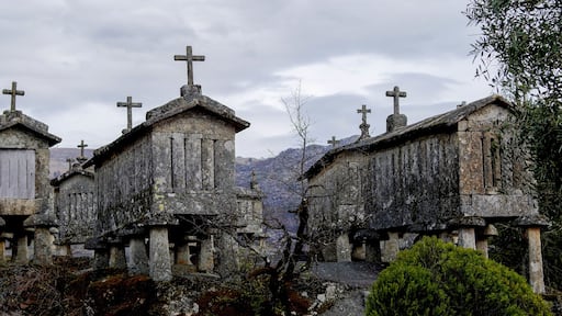 Une rangée de croix en pierre se dresse au sommet d’une colline, sous un ciel nuageux.