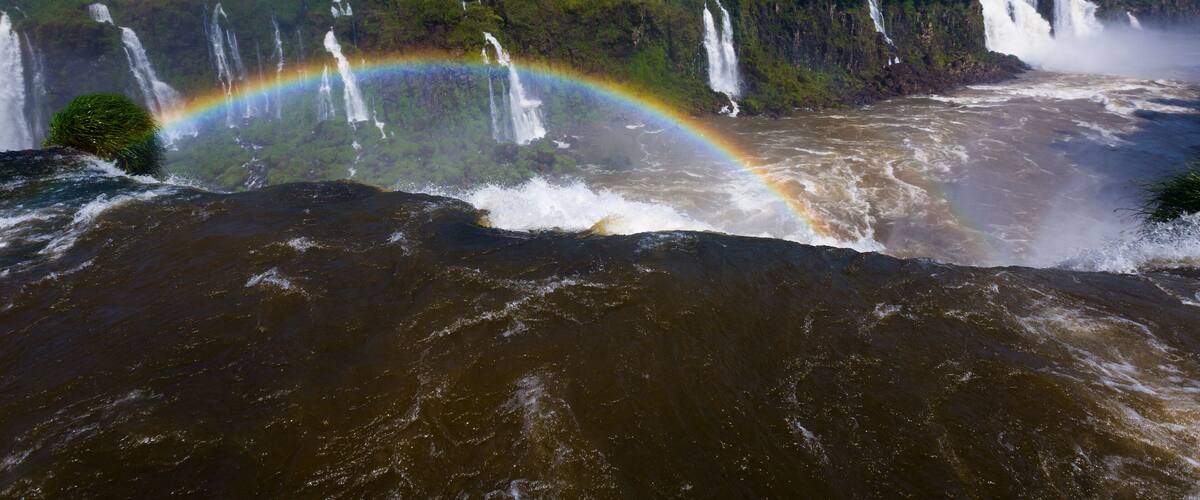 A waterfall with a rainbow arching over it.