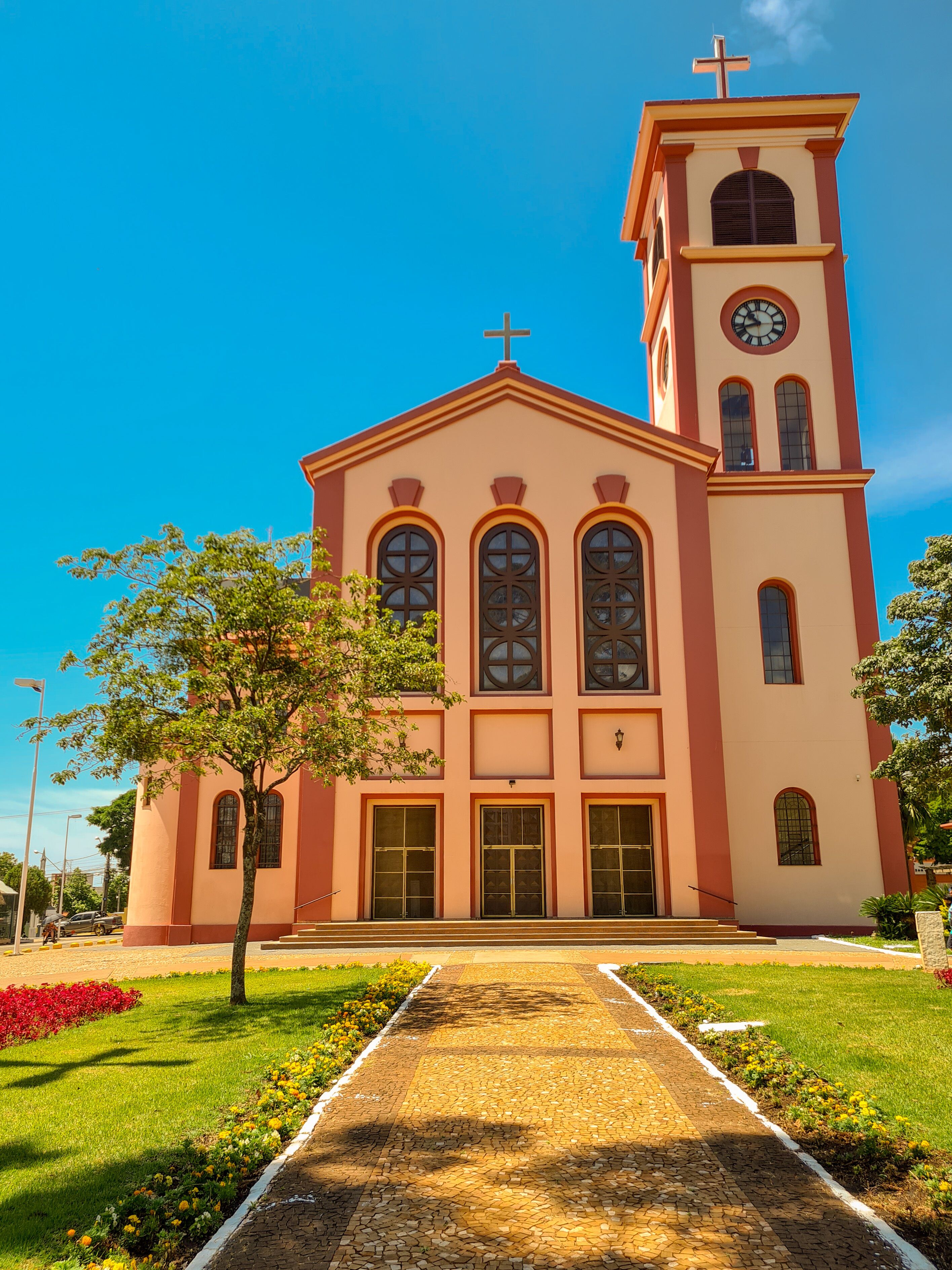 A church with a clock tower and a cross on top.