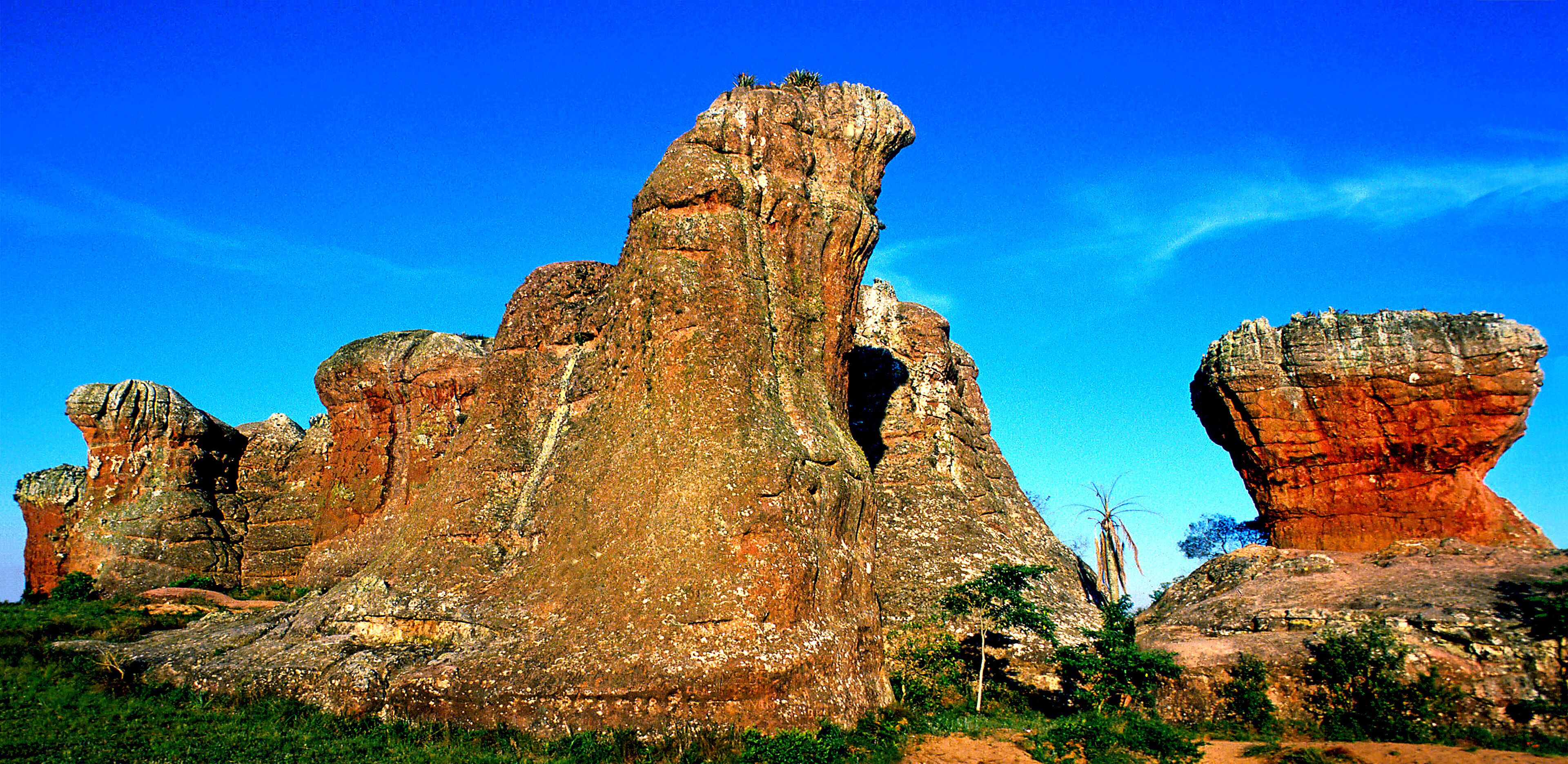 A large rock formation with a prominent cave-like opening.