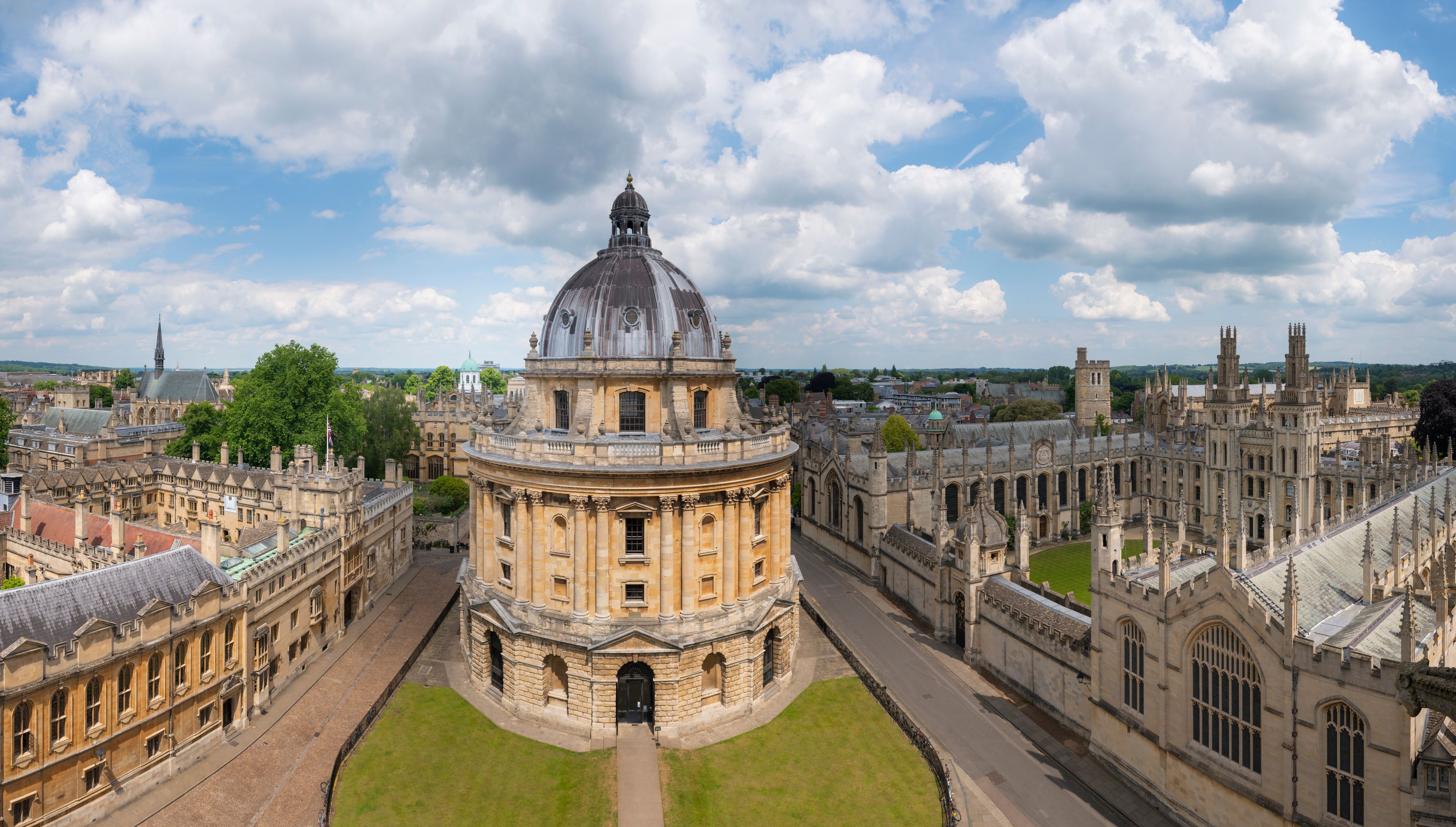 A historic university campus with a prominent central dome, surrounding classical buildings, and a clear sky.