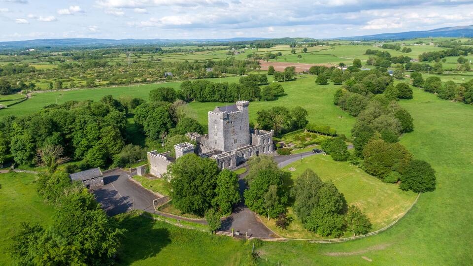 A large castle surrounded by lush green fields and trees.