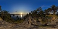 A sunset over a lake with a rocky shoreline and trees.