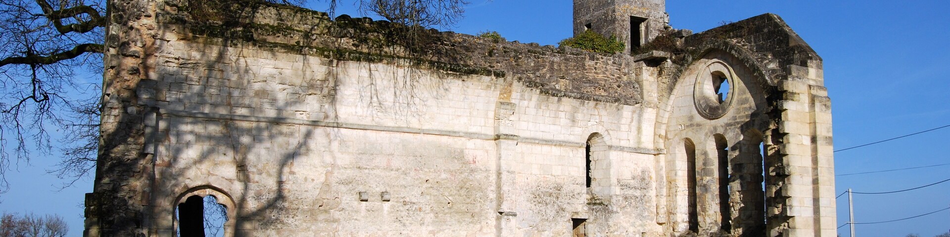 An old stone church with a bell tower and arched windows.