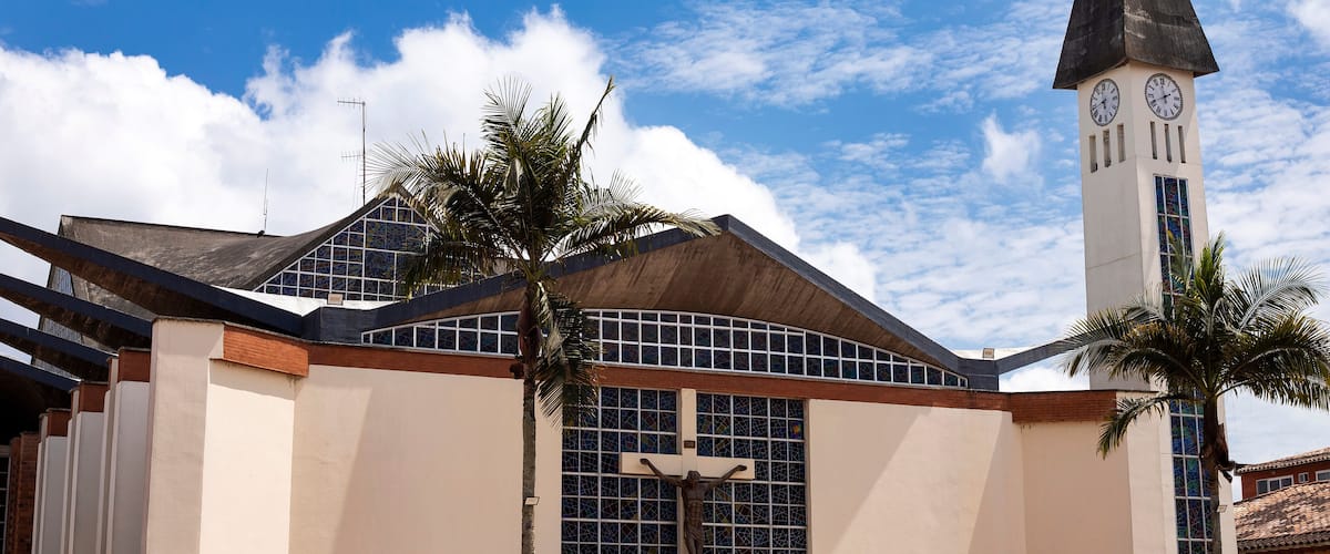 A church with a tall steeple and a cross on the facade.