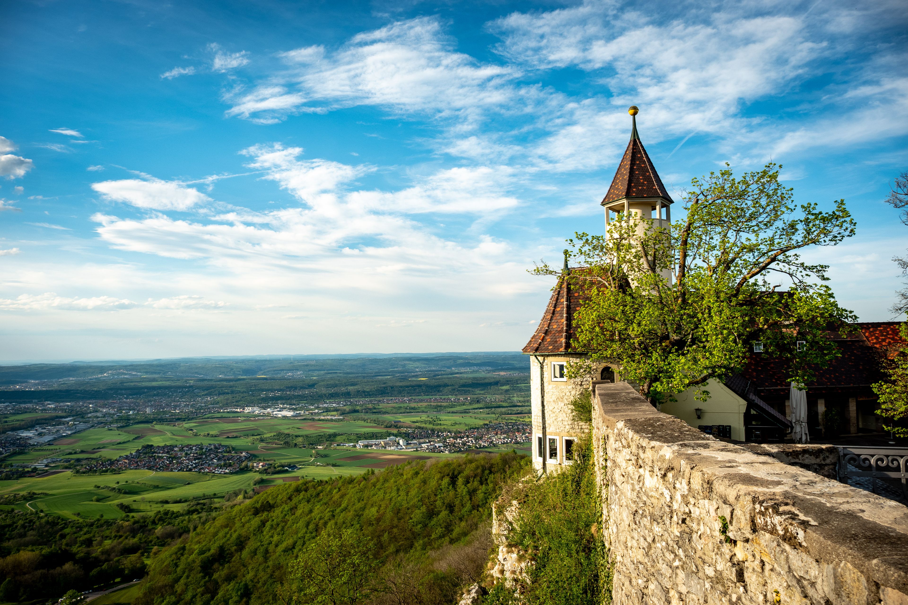 Eine Burg mit einem Turm, der über ein Tal blickt.