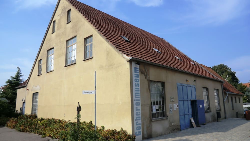 Ein Gebäude mit rotem Ziegeldach und einem Schild mit der Aufschrift 'Hasenpatt'.