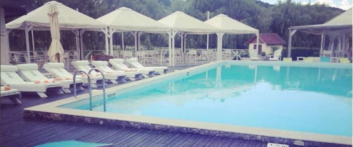 A swimming pool with lounge chairs and umbrellas.