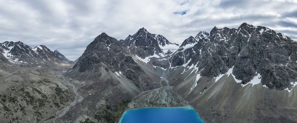 A mountain range with sharp peaks and a glacier.