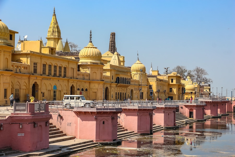 Un edificio amarillo con cúpulas y un puente sobre un río.