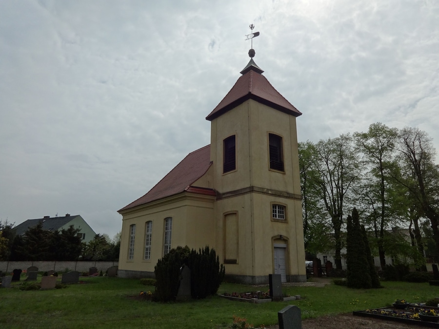 A church with a red roof and a weather vane.