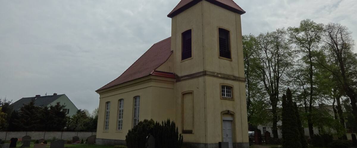 A church with a red roof and a weather vane.