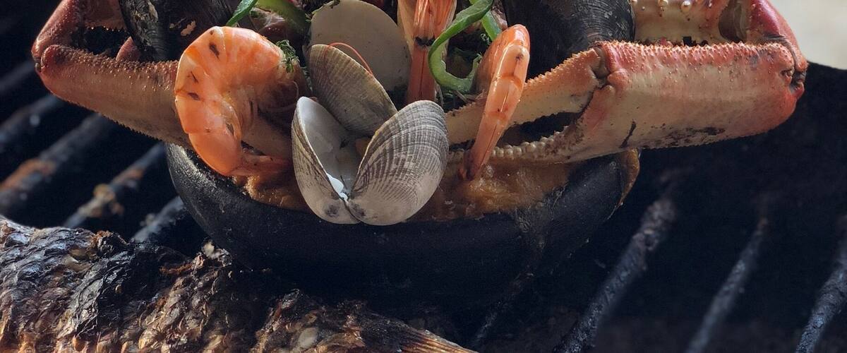 A seafood grill with grilled fish, shrimp, clams, and mussels.