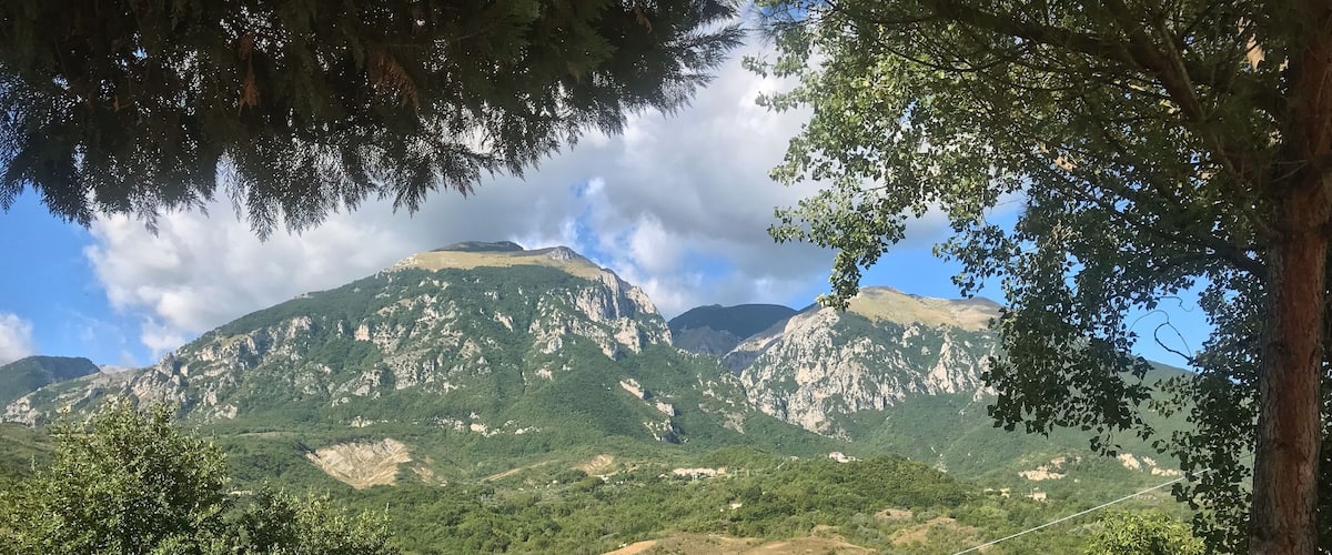 A mountainous landscape with dense forests and a clear sky.