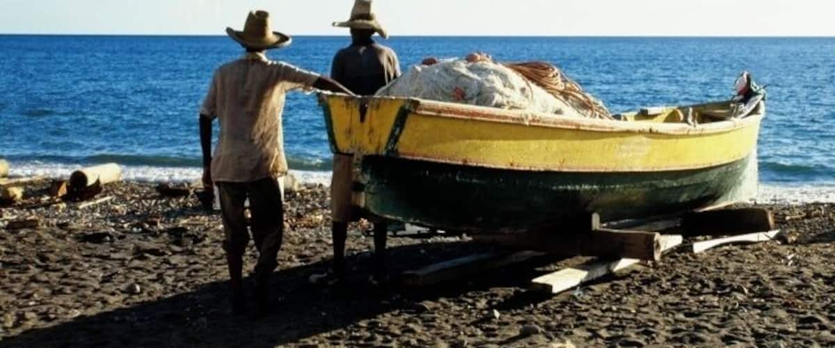 Two people on a beach with a boat.