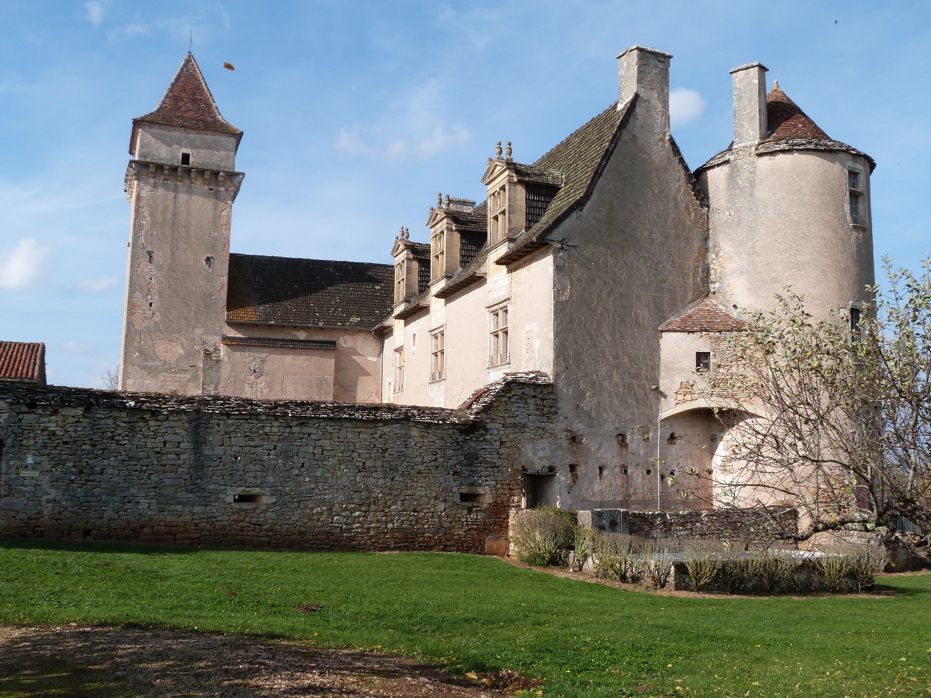 A historic castle with stone walls, a tower, and a large turret.